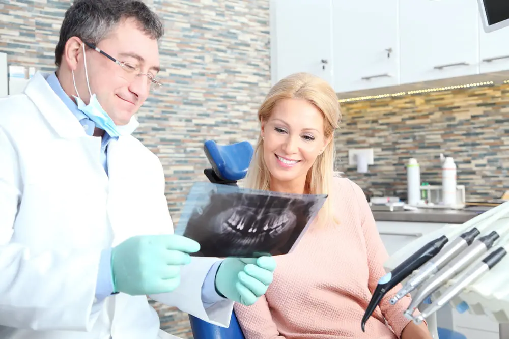 Male dentist showing x-ray