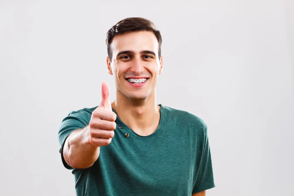 Man with braces showing thumbs up