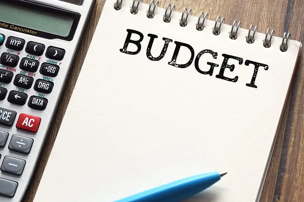 On a wooden surface at Orthodontic Design Co. Orthodontics in Madison and Huntsville, AL, a calculator, blue pen, and notepad labeled "BUDGET" are arranged. Represent about braces payment plan options. On a wooden surface at Orthodontic Design Co. Orthodontics in Madison and Huntsville, AL, a calculator, blue pen, and notepad labeled "BUDGET" are arranged. Represent about braces payment plan options.