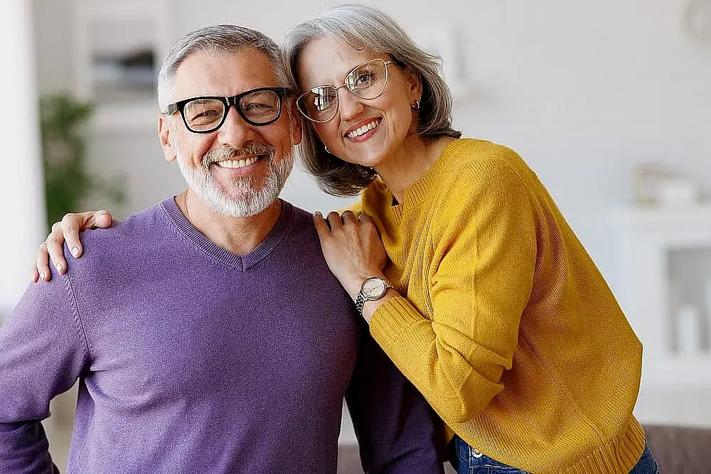 Smiling at the camera, an older man and woman stand close indoors; looking for good Invisalign Payment Plan at Orthodontic Design Co. Orthodontics in Madison and Huntsville, AL. Smiling at the camera, an older man and woman stand close indoors; looking for good Invisalign Payment Plan at Orthodontic Design Co. Orthodontics in Madison and Huntsville, AL.