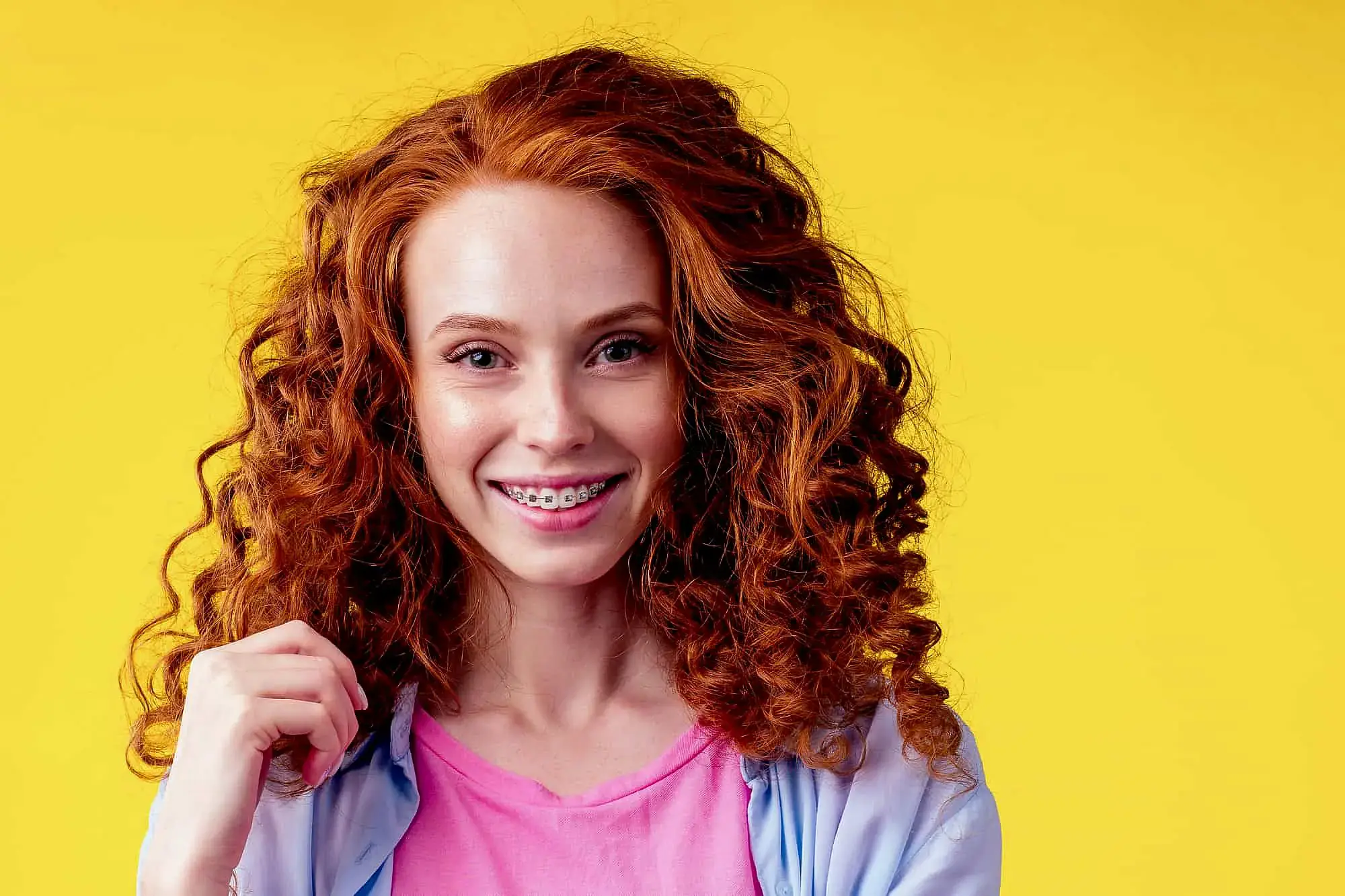 Smiling young woman with curly red hair and braces for Orthodontic Design Co. Orthodontics in Madison and Huntsville, AL. Smiling young woman with curly red hair and braces for Orthodontic Design Co. Orthodontics in Madison and Huntsville, AL.