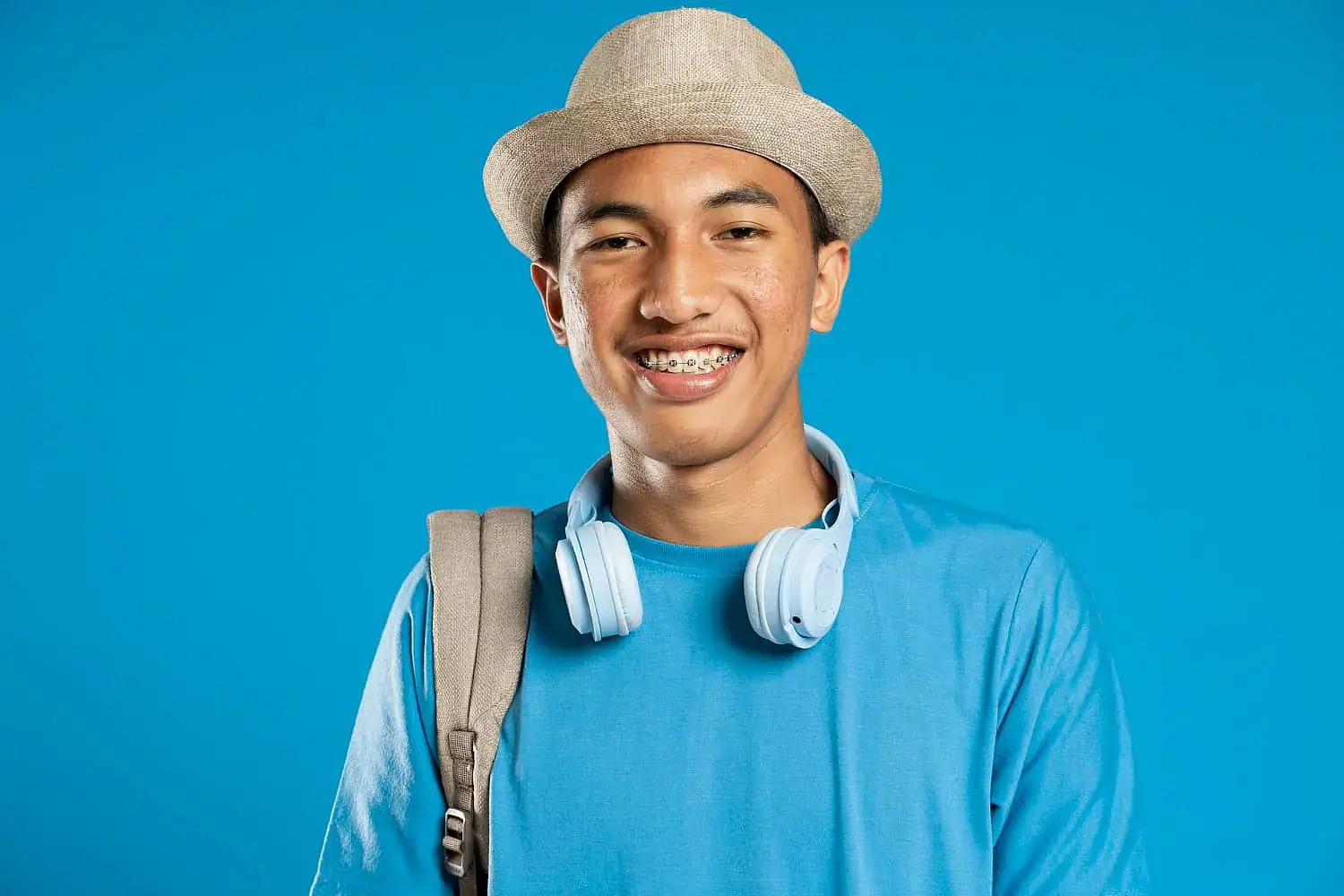 Smiling young person with beige hat and headphones, considering braces cost for Orthodontic Design Co. Orthodontics in Madison and Huntsville, AL. Smiling young person with beige hat and headphones, considering braces cost for Orthodontic Design Co. Orthodontics in Madison and Huntsville, AL.