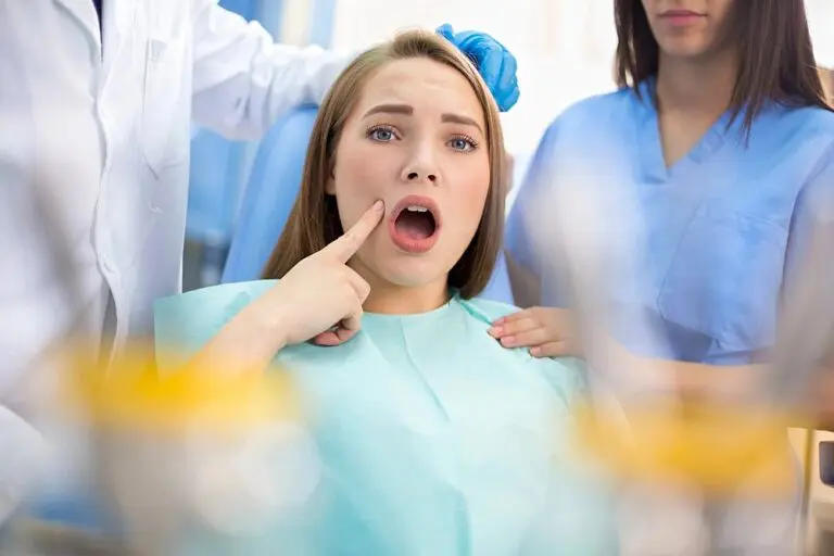 A concerned woman in a dental chair points to her mouth as two staff from Orthodontic Design Co. Orthodontics in Madison and Huntsville, AL stand by - Overbite vs Underbite in Madison and Huntsville, AL.